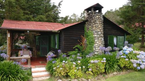 a small cabin with flowers in front of it at Villa Pajon Eco Lodge in Constanza