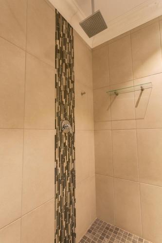 a bathroom with a shower with a glass door at Royl Court Guesthouse in Kimberley