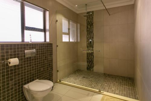 a bathroom with a shower and a toilet at Royl Court Guesthouse in Kimberley