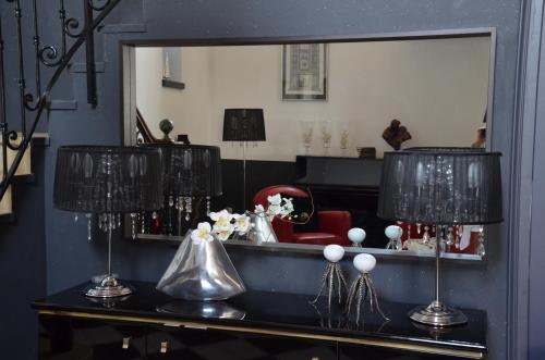 a room with a mirror and a table with two lamps at La Petite Aiguebonne in Allex
