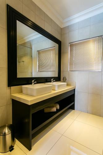 a bathroom with two sinks and a large mirror at Royl Court Guesthouse in Kimberley