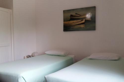 two beds in a room with a painting on the wall at Hotel Zapata in Boca Chica