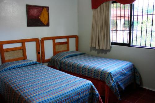 a room with two beds and a window at Hotel Zapata in Boca Chica