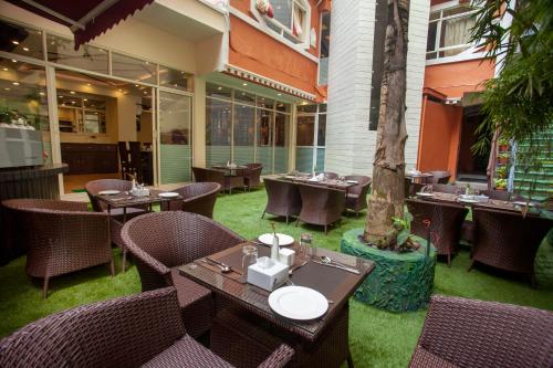 un restaurant avec des tables, des chaises et un arbre dans l'établissement Hotel Jampa, à Katmandou