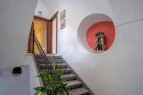 a stairway with a statue of a woman on a wall at Rosa Magra Guest House in Sorrento