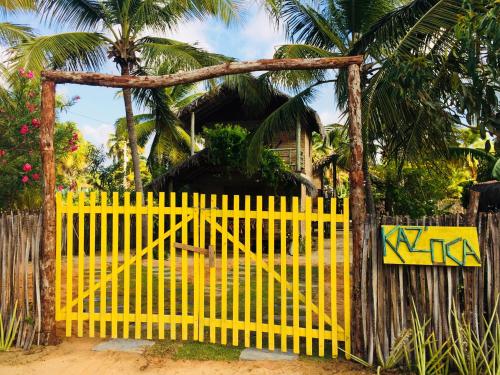 a yellow gate with graffiti on it in front of a house at Pousada kaz'oca in Icaraí