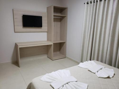 1 dormitorio con 1 cama con toallas en Villa de Holanda Parque Hotel, en Holambra