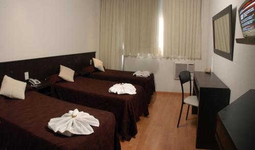 Habitación de hotel con 2 camas y escritorio en Altos Del Valle en Villa Carlos Paz