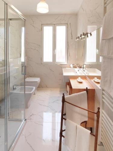 a bathroom with two sinks and a toilet and a shower at Boutique Hotel Albero Nascosto in Trieste