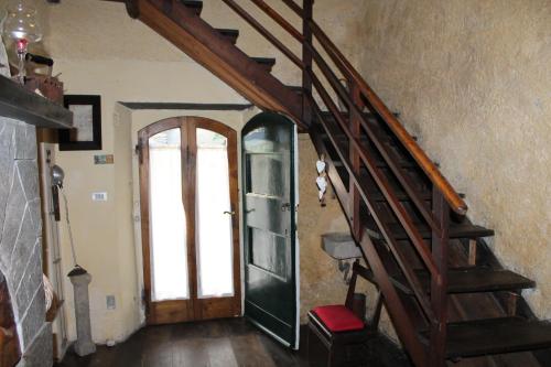 a hallway with a wooden staircase and a door at Casa Emilia in Stazzema