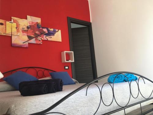 a bedroom with a bed and a red wall at Casa Escape in Terrasini