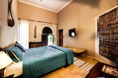 a bedroom with a bed and a tv on a wall at Riad les Ammonites and Spa in Marrakech