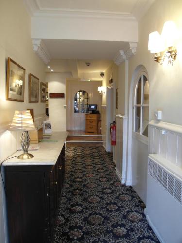 a hallway of a home with a lamp on a table at Best Western The George Hotel, Swaffham in Swaffham