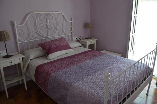 チクラナ・デ・ラ・フロンテーラにあるUrbanización San Andrés Golf El Olivarのベッドルーム(白いベッド、紫色の掛け布団付)