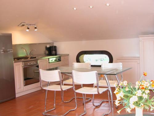 a kitchen with a table and white chairs at Villa Rita in Domaso