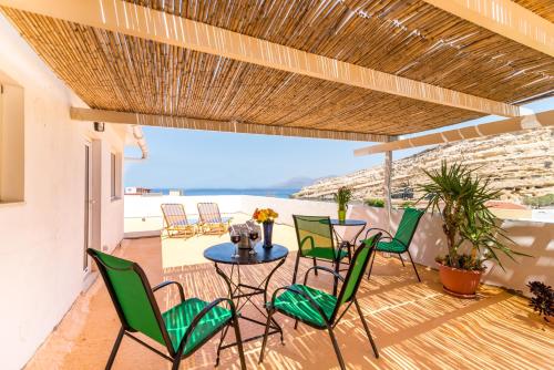 a patio with chairs and a table with a view of the ocean at Hotel Sofia in Matala