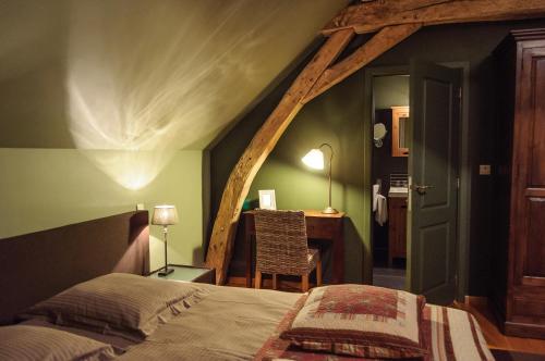 a bedroom with a bed and a desk in a room at B&B Het Hof van Petronilla in Gooik