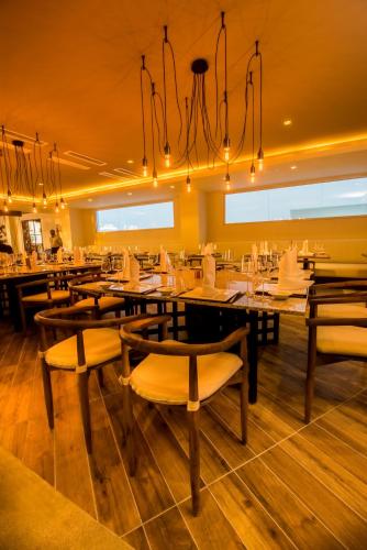 a restaurant with tables and chairs and a chandelier at Presidential Suites Cabarete - Room Only in Cabarete