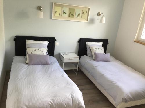 - 2 lits dans une chambre avec une table de chevet dans l'établissement La Ressource, à Fontguenand