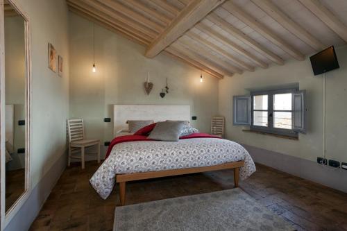 um quarto com uma cama grande e uma janela em Scalette di Piazza B&B em Montalcino