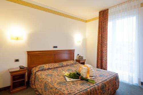 una camera d'albergo con un letto fiorito di Hotel Bologna a Bardolino