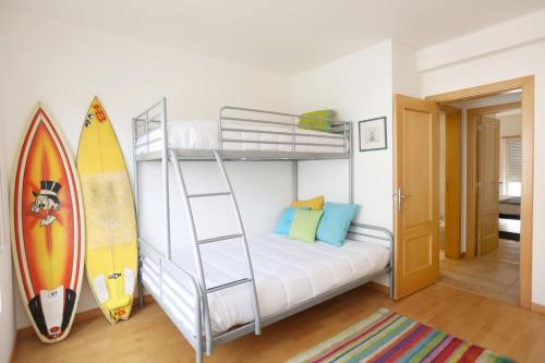 - une chambre avec des lits superposés et une planche de surf dans l'établissement Like-home-T2 Apt-Blue Dreams-sea view, à Ericeira
