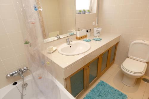 La salle de bains est pourvue d'un lavabo, de toilettes et d'une baignoire. dans l'établissement Like-home Blue Dreams, à Ericeira