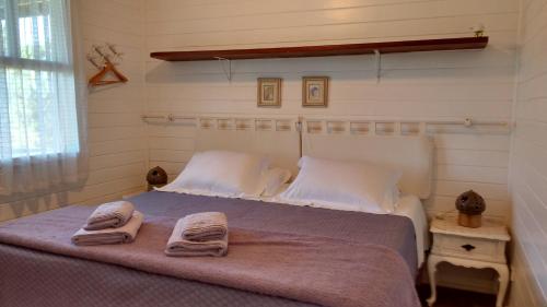 a bedroom with a bed with towels on it at Pousada Recanto das Girafas in Cunha