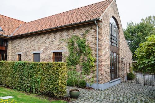 a brick building with a fence in front of it at B&B Het Hof van Petronilla in Gooik