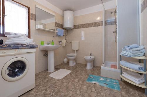a bathroom with a washing machine and a toilet at Guest House Robert i Mirna in Bale