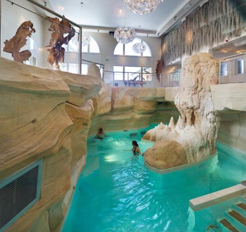 une piscine dans un hôtel avec des gens dans l'eau dans l'établissement Arc 1950 Appartement skis aux pieds, à Arc 1950