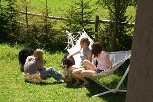 a group of girls sitting in a hammock with a dog at Tiefhof in Nauders