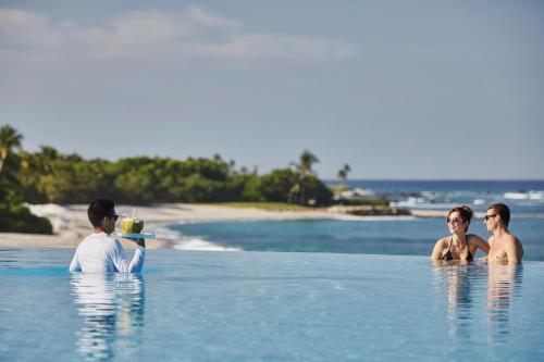 a group of three people in the water at a resort at Four Seasons Resort Punta Mita in Punta Mita