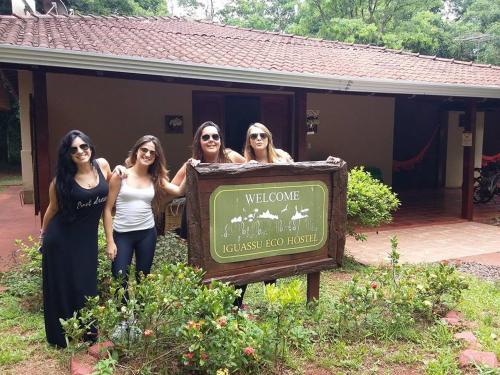 a group of women standing next to a welcome sign at IguassuEcoHostel - Eco Suítes - Hostel mais próximo das Cataratas in Foz do Iguaçu