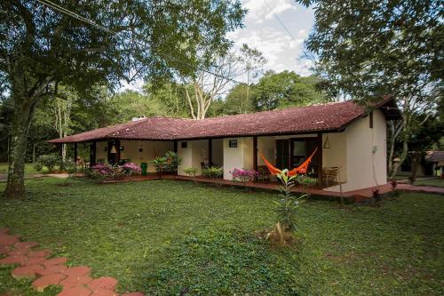 uma pequena casa com um quintal em frente em Iguassu Eco Hostel - IguassuEcoHostel - Eco Suítes em Foz do Iguaçu