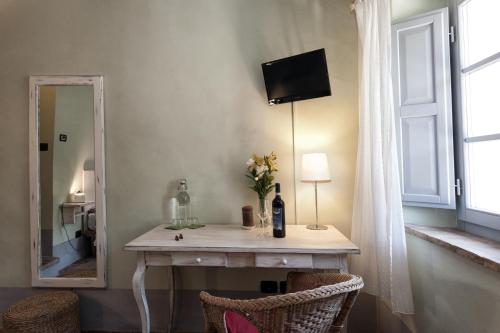 a room with a table with a mirror and a window at Scalette di Piazza B&B in Montalcino