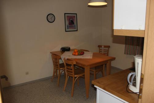 een keuken met een tafel met stoelen en een klok aan de muur bij Ferienwohnungen Goldbach 1. Stock in Regensburg