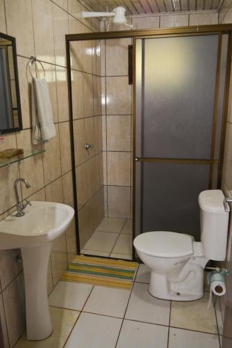 a bathroom with a shower and a toilet and a sink at IguassuEcoHostel - Eco Suítes - Hostel mais próximo das Cataratas in Foz do Iguaçu