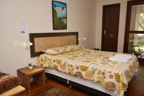 a bedroom with a bed and a table in it at IguassuEcoHostel - Eco Suítes - Hostel mais próximo das Cataratas in Foz do Iguaçu