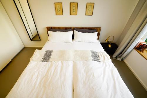 メーアブッシュにあるHaus am See - Meerbusch / Düsseldorfのベッドルーム1室(白いシーツと枕のベッド1台付)