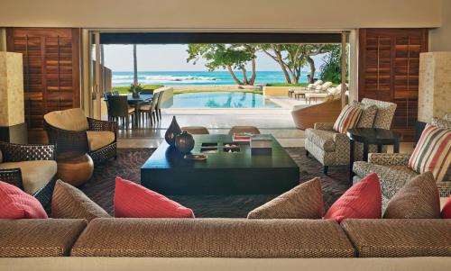 a living room with a couch and a table and a pool at Four Seasons Resort Punta Mita in Punta Mita