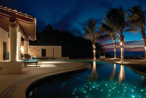 a swimming pool at night with palm trees at Four Seasons Resort Punta Mita in Punta Mita