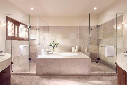a bathroom with a tub and a glass shower at Four Seasons Resort Punta Mita in Punta Mita