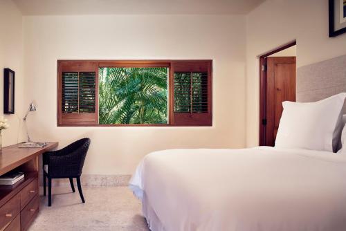 a bedroom with a bed and a desk and a window at Four Seasons Resort Punta Mita in Punta Mita