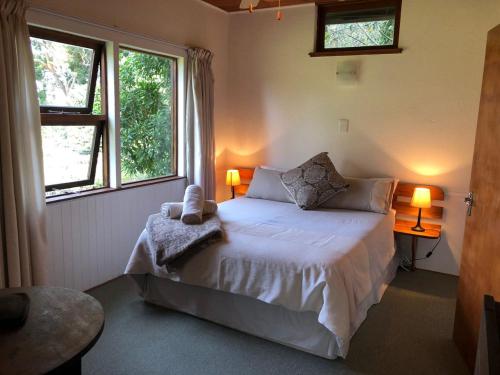 a bedroom with a large bed with two windows at Natures Way Farm Cottage in The Crags