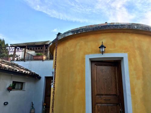 a yellow building with a door and a balcony at C'era una volta Podere San Giovanni in Fossacesia