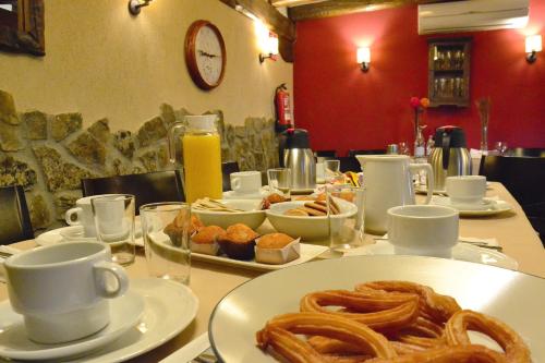 a table with a plate of pretzels and coffee cups at La Casa del Solaz in Anaya