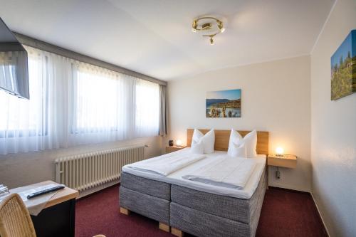 una camera d'albergo con un grande letto e una finestra di Hotel Bisenius a Traben-Trarbach