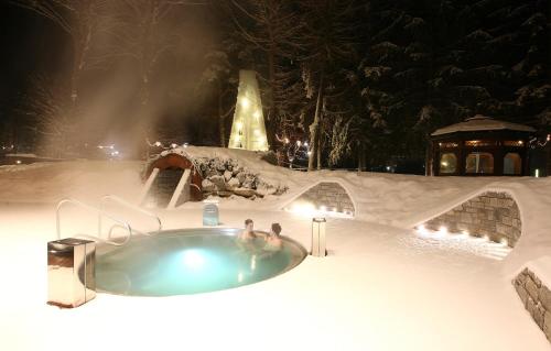 two people in a hot tub in the snow at Miramonti Park Hotel in Bormio