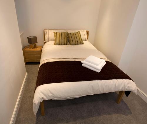 a bed room with a white bedspread and pillows at Aberdeen Serviced Apartments - The Lodge in Aberdeen